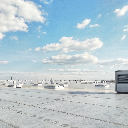 Commercial flat roof under bright sunlight illustrating UV exposure on roofing materials.