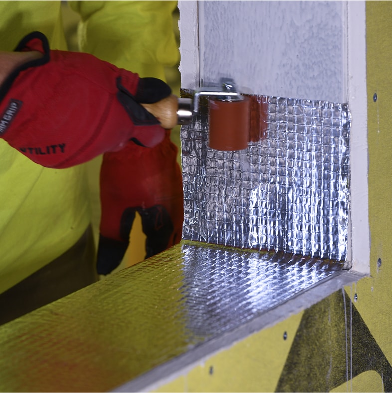 Flashing installed at a window corner of a commercial building wall.