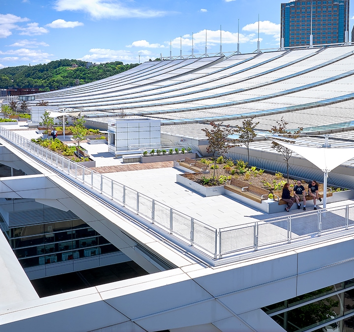 Green rooftop with planters and seating, showcasing a single-source solution provider’s integrated roofing design.