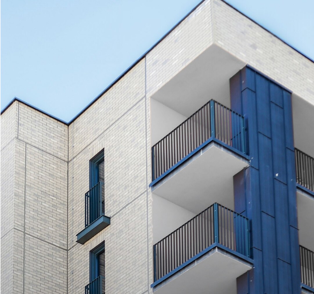 Exterior Wall System on a commercial building under a bright blue sky.