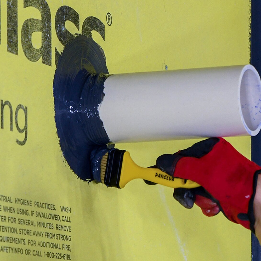 Applying WALLcontrol STPE liquid flashing around a wall pipe penetration.