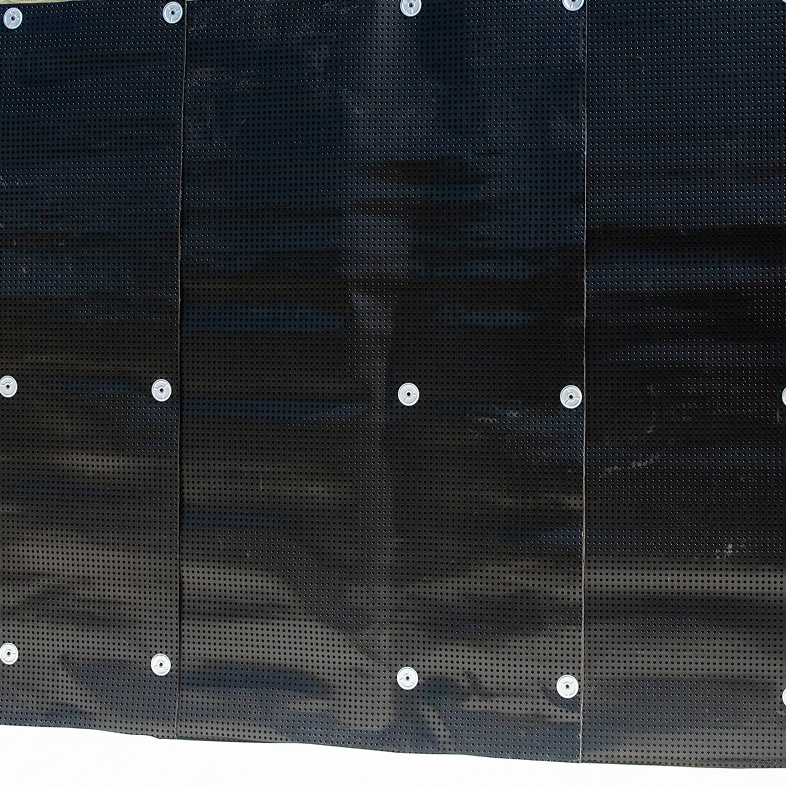 Close-up of the black dimpled TeraPROOF™ 10-11 Drainage Mat installed, showing its perforated surface and fasteners.