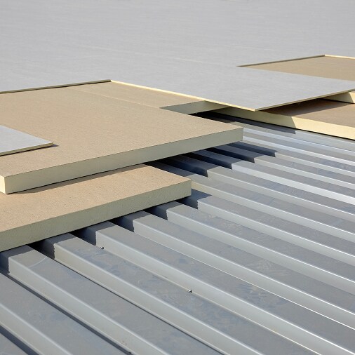 Layers of rigid insulation shown on a metal deck, demonstrating advanced insulation and reflective design to maximize R-value.