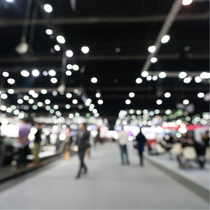 Illumination inside a large convention center hall hosting GAF and Siplast building and roofing science technical events.