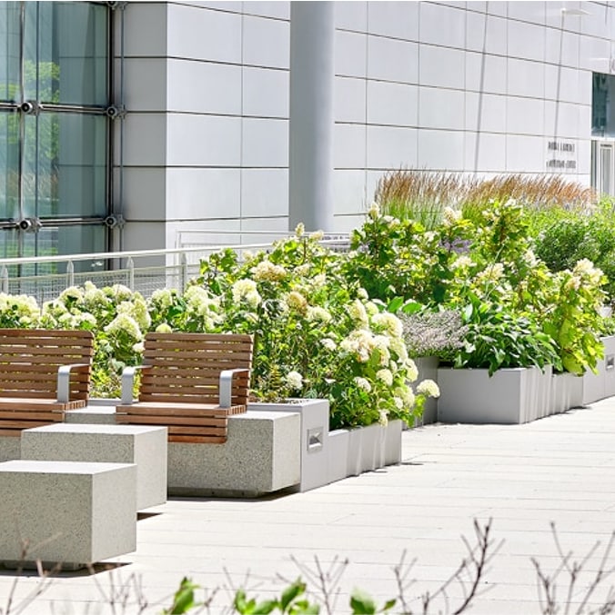 Rooftop amenity space with container plantings, seating, and tables