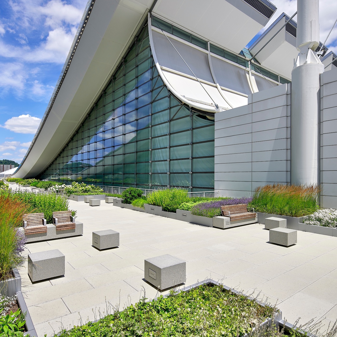 Rooftop amenity space at the David L. Lawrence Convention Center, featuring modern architecture, green planters, and paved seating areas.