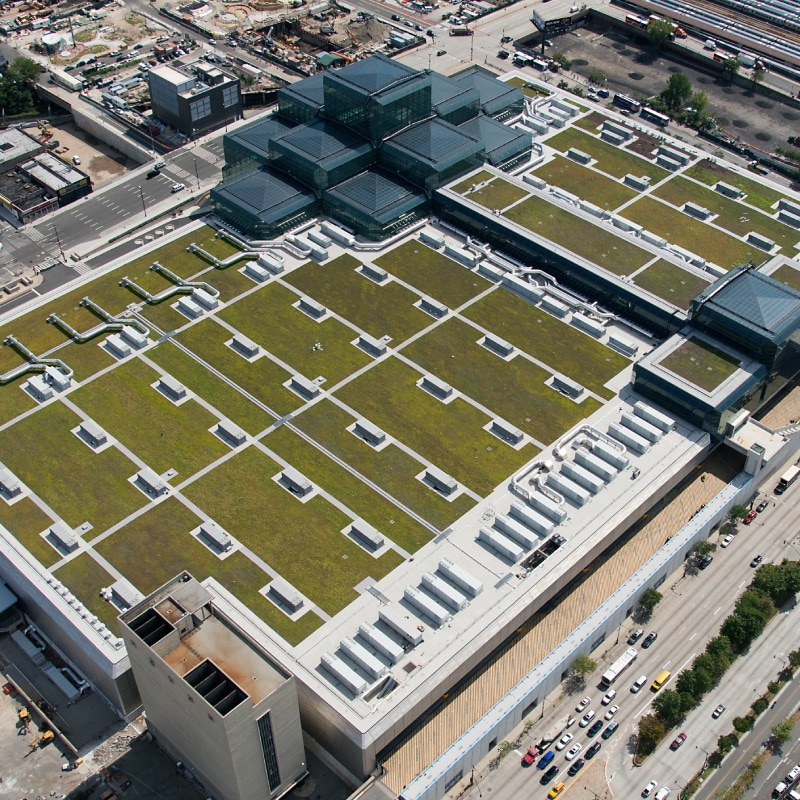Aerial view of a large commercial building with an extensive green roof, illustrating the Waterproofing Design for Vegetated Roofs webinar.