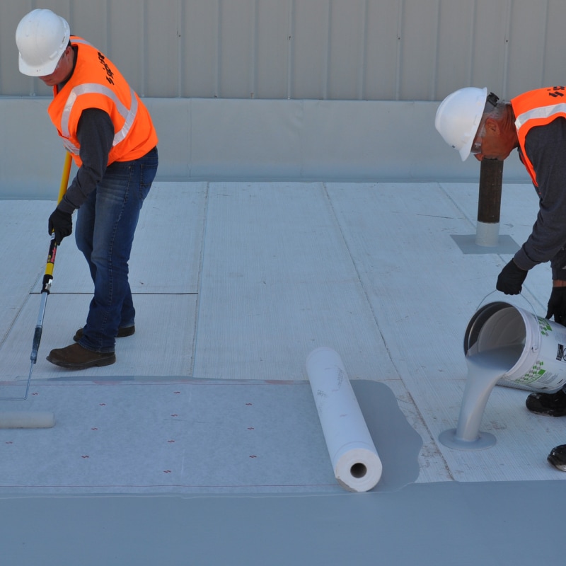 Contractors install a liquid-applied roof, illustrating a webinar course on Liquid-Applied PMMA Roof Membranes and systems.