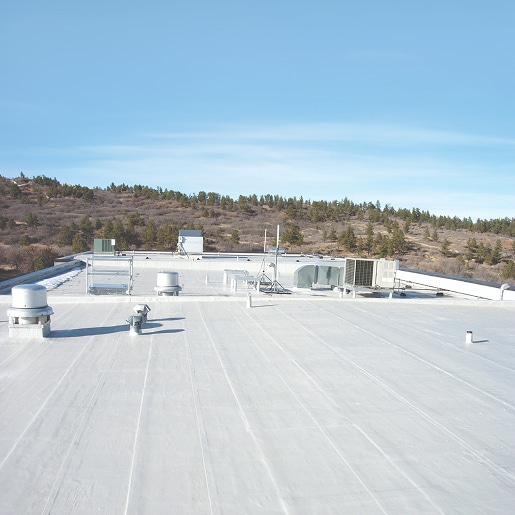 Liquid-applied PMMA roofing system on a commercial building roof.