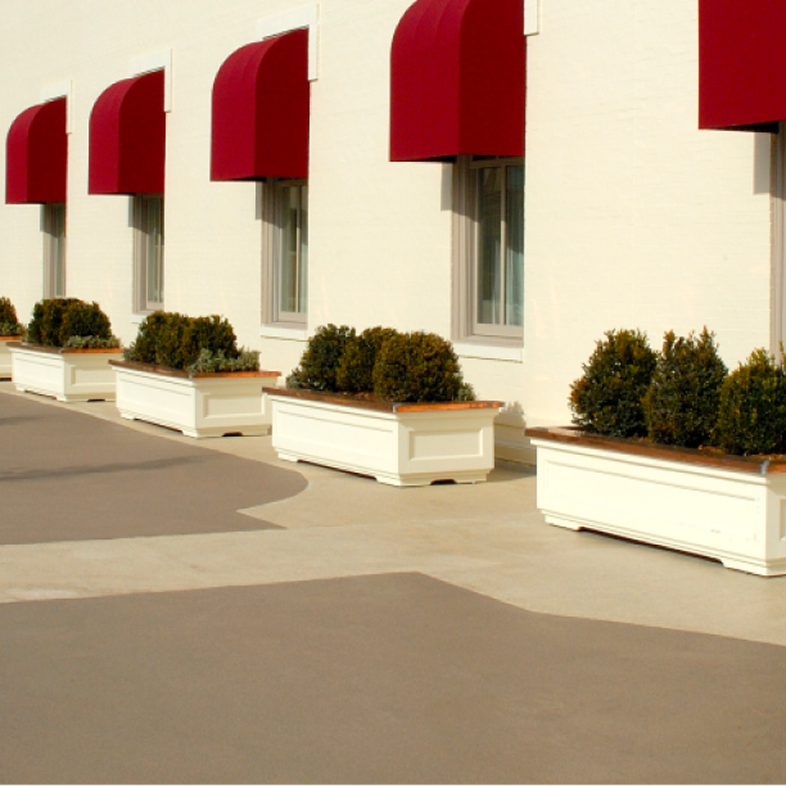 Liquid-applied traffic coatings with planter boxes next to a building with red awnings.