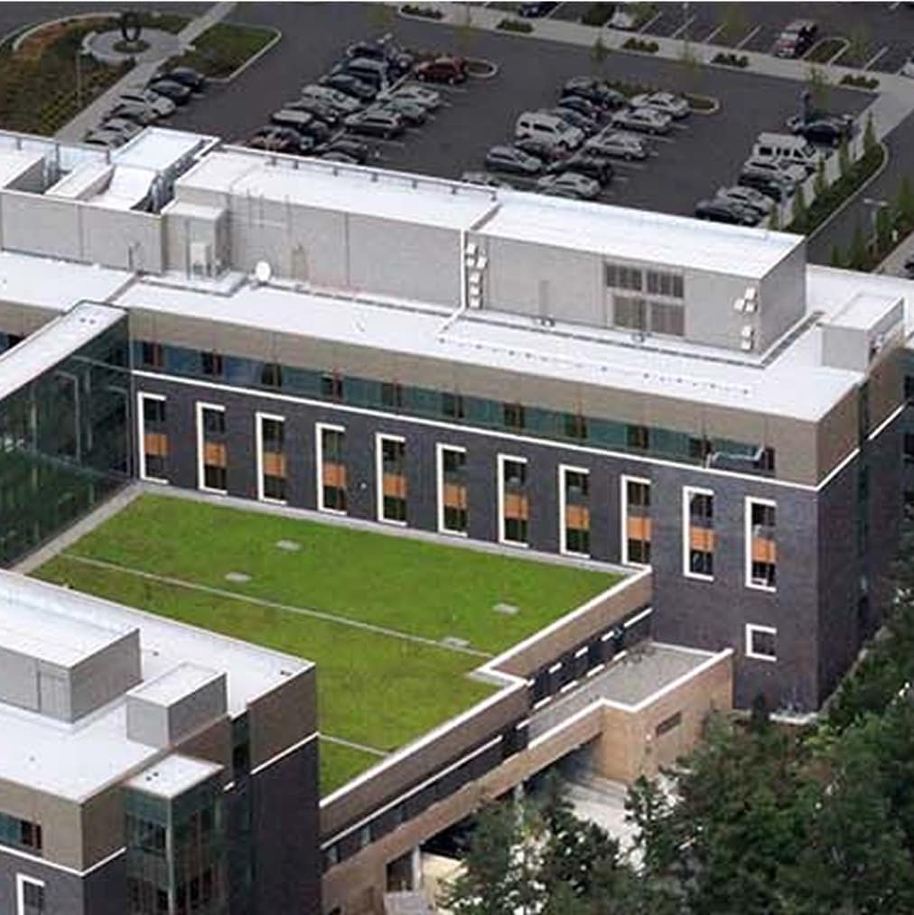 An aerial view of the modern Swedish Hospital complex with a mix of light-colored and green roofs, illustrating a large-scale commercial building project where Siplast roofing and waterproofing systems provide long-term protection and peace of mind for building owners.