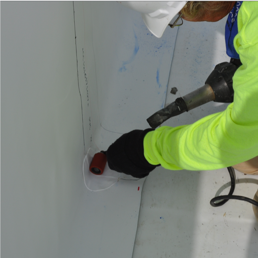 A worker in a yellow shirt performs roof repair and maintenance, symbolizing Siplast's guide on maximizing a roof's service life.