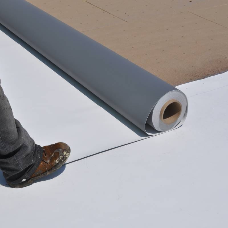 Contractor's foot and a roll of gray PVC roofing membrane being installed for the PVC Membranes & Systems webinar.