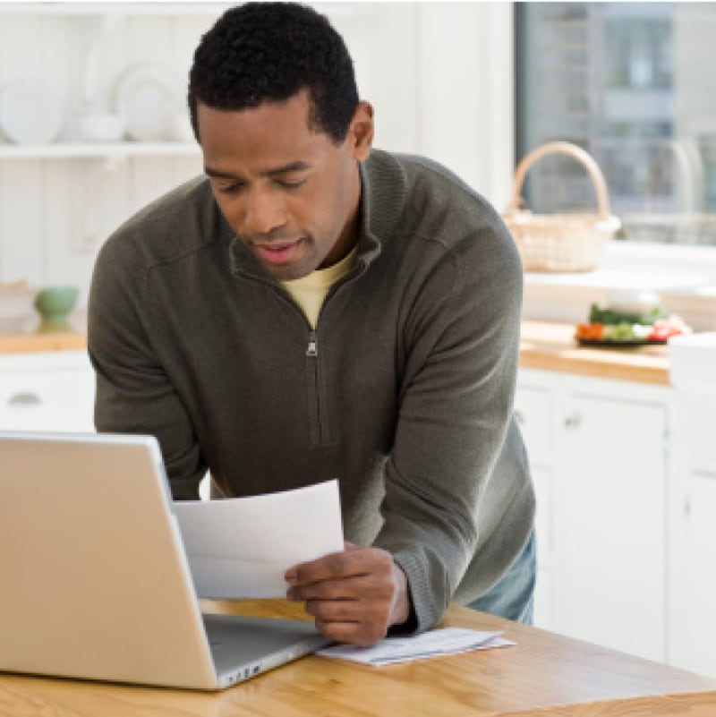 Man reviewing finances with laptop