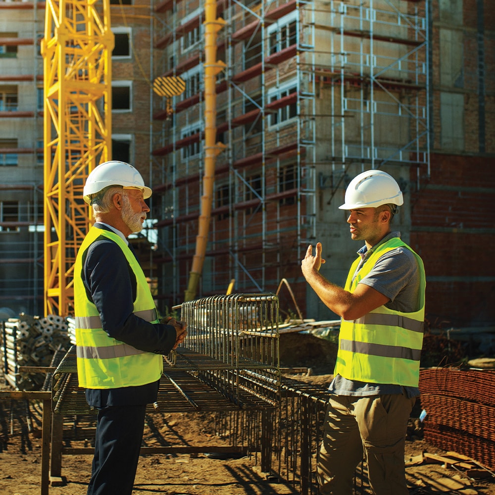 Contractor discussing commercial project specifications with a building owner on a jobsite.