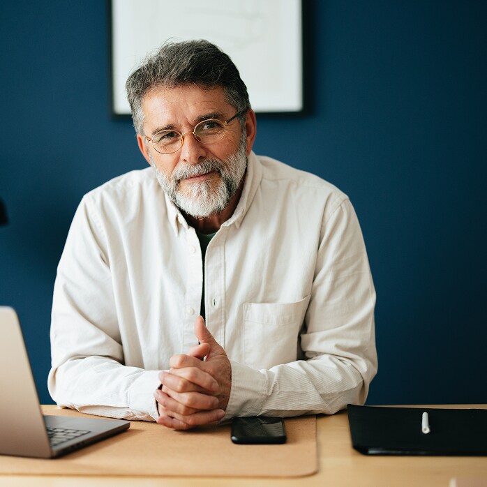 Mature male building owner sitting at his desk, representing Building Owner Resources for finding contractors and guarantee info.