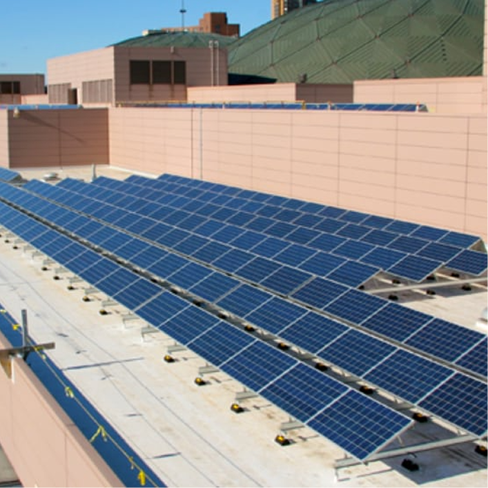 Roof-mounted photovoltaic solar panel array installed on a commercial low-slope roof, demonstrating renewable energy infrastructure on a building.