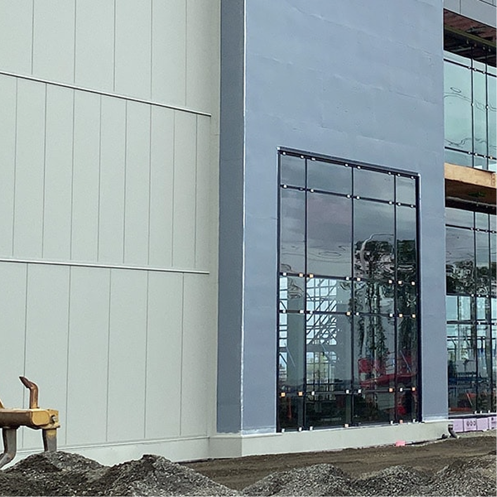 Modern commercial building enclosure with glass and metal panels, illustrating design and construction.