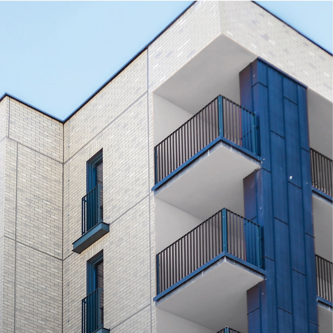 High-rise building under construction with exposed framework and a crane, showcasing installation of air and water-resistive barriers for building envelope protection.