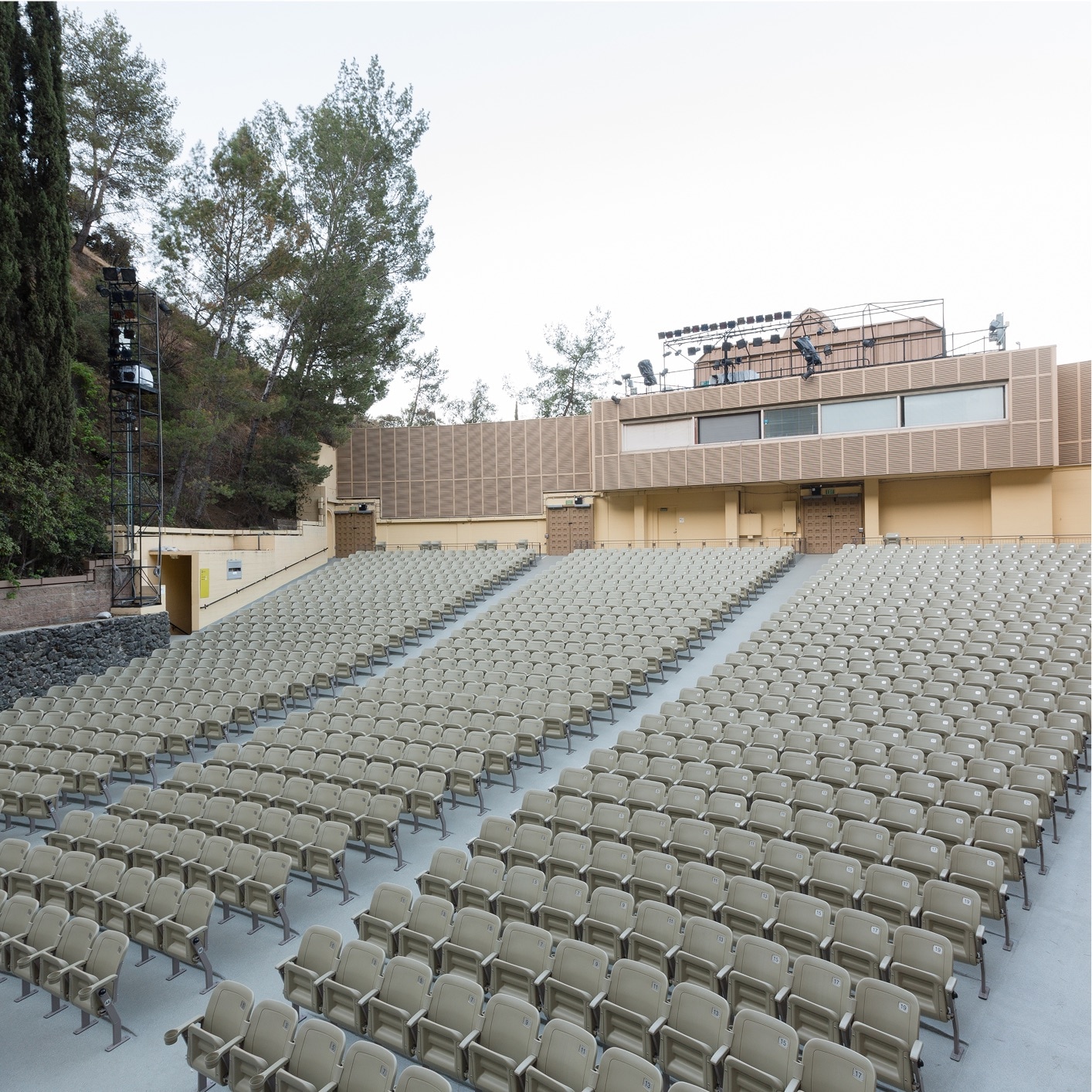 Outdoor amphitheater or stadium seating with rows of empty beige chairs, indicating PMMA application for durable and weather-resistant stadium flooring or surfacing.