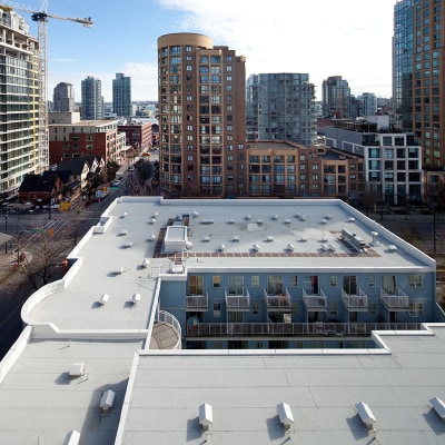 White SBS-modified bitumen roof membrane on a commercial building, illustrating the Surfacing & Reinforcement Solutions webinar.