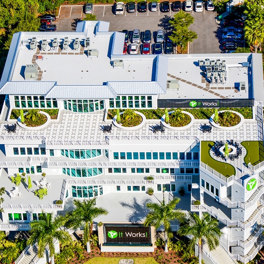 Aerial view of a building with a patterned rooftop garden and surrounding urban area