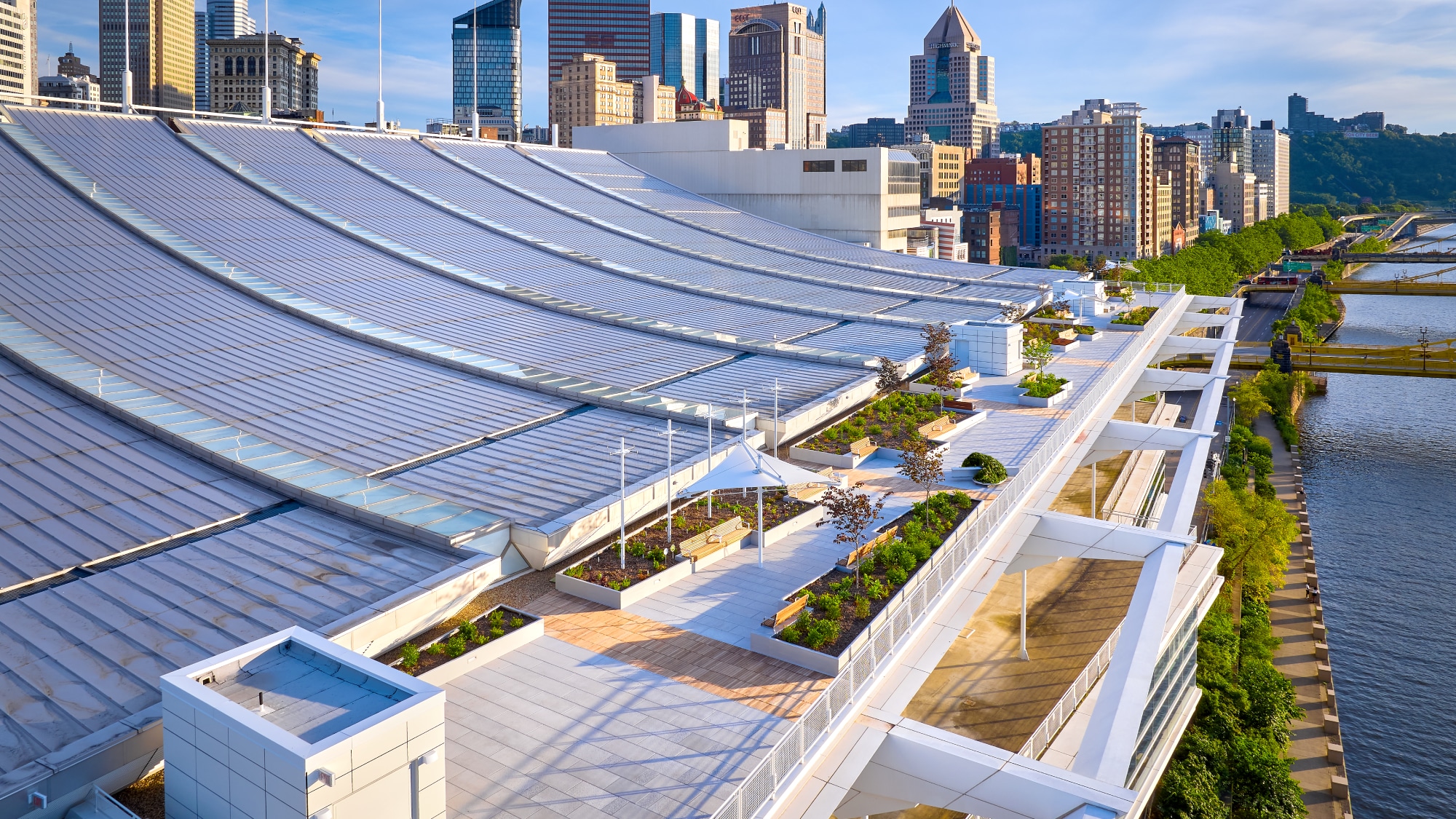 Rooftop of the David L. Lawrence Convention Center with a curved metal roof, green spaces, and paved walkways
