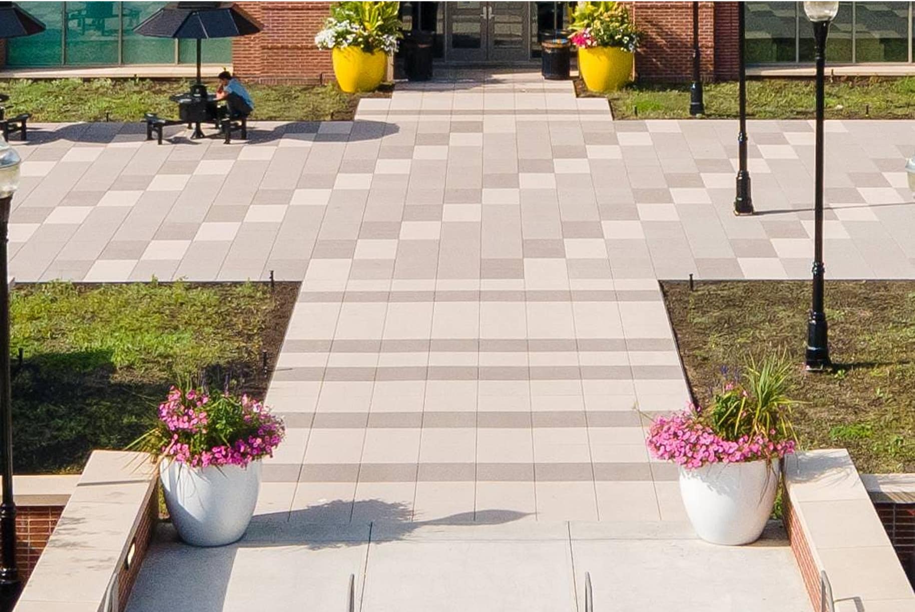 Green roof plaza with modular pavers, integrated planters, and seating area, showcasing sustainable rooftop landscaping design