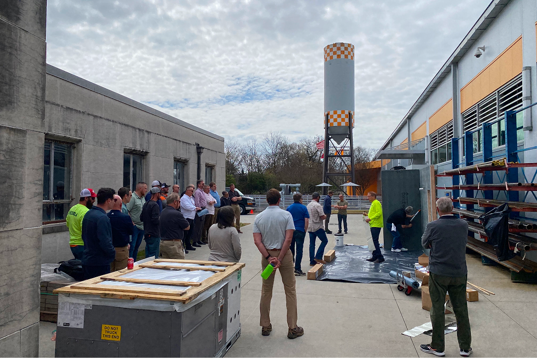 A group of professionals attends a hands-on outdoor demonstration for continuing education (CEU) on a commercial site.