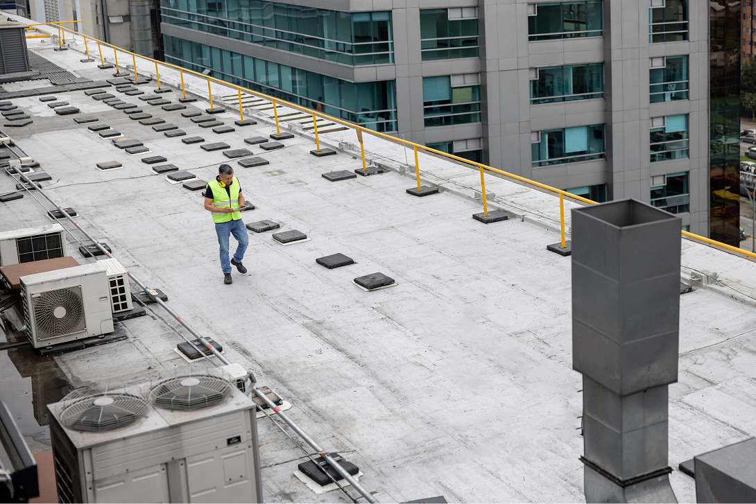 A technician inspects a white commercial rooftop, symbolizing the process for guarantee services and how to submit a claim.