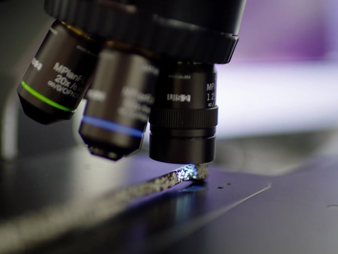Close-up of a microscope viewing a sample, symbolizing leading innovation in SBS roofing technology and product testing.