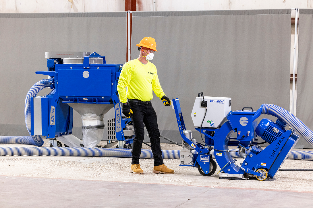 A Siplast Select Contractor uses a blue shot blaster to prepare a deck, symbolizing the high standards for contractors.