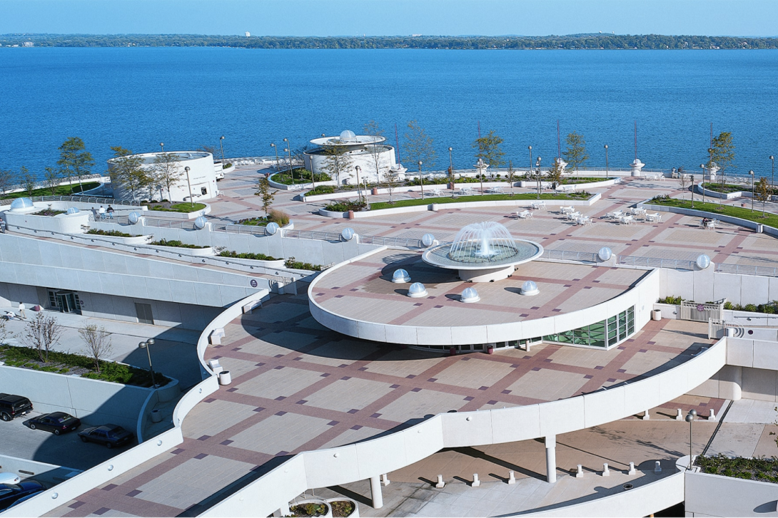 An expansive commercial plaza deck overlooking a body of water, highlighting Siplast's liquid-applied plaza deck solutions.