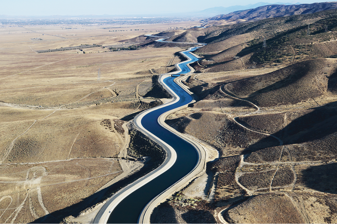 Aerial view of a long, winding canal lined with Siplast's Teranap Geomembrane for civil engineering solutions.