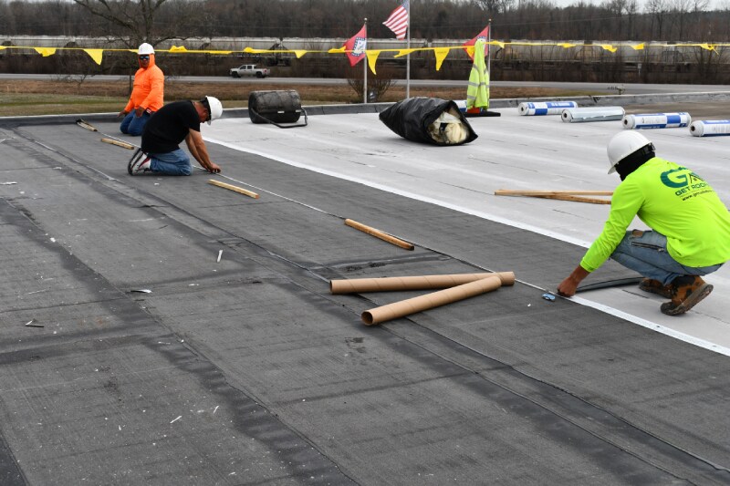 Roofers installing a hybrid roof system by Siplast