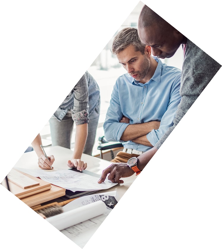 Two people looking at architectural or construction plans together, pointing and discussing details