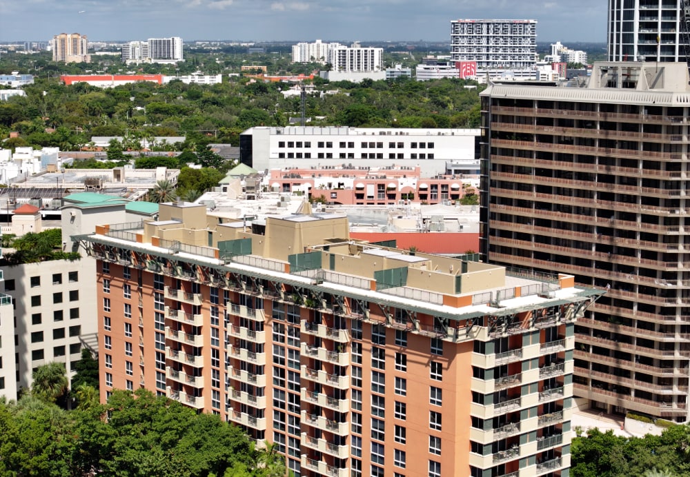 High-angle perspective of the multi-story hotel building featuring a newly installed flat roofing system surrounded by an urban skyline.