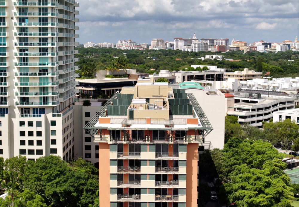 Aerial view of the hotel’s tiered flat roof systems and balconies, showcasing the completed light-colored membrane and perimeter railing.