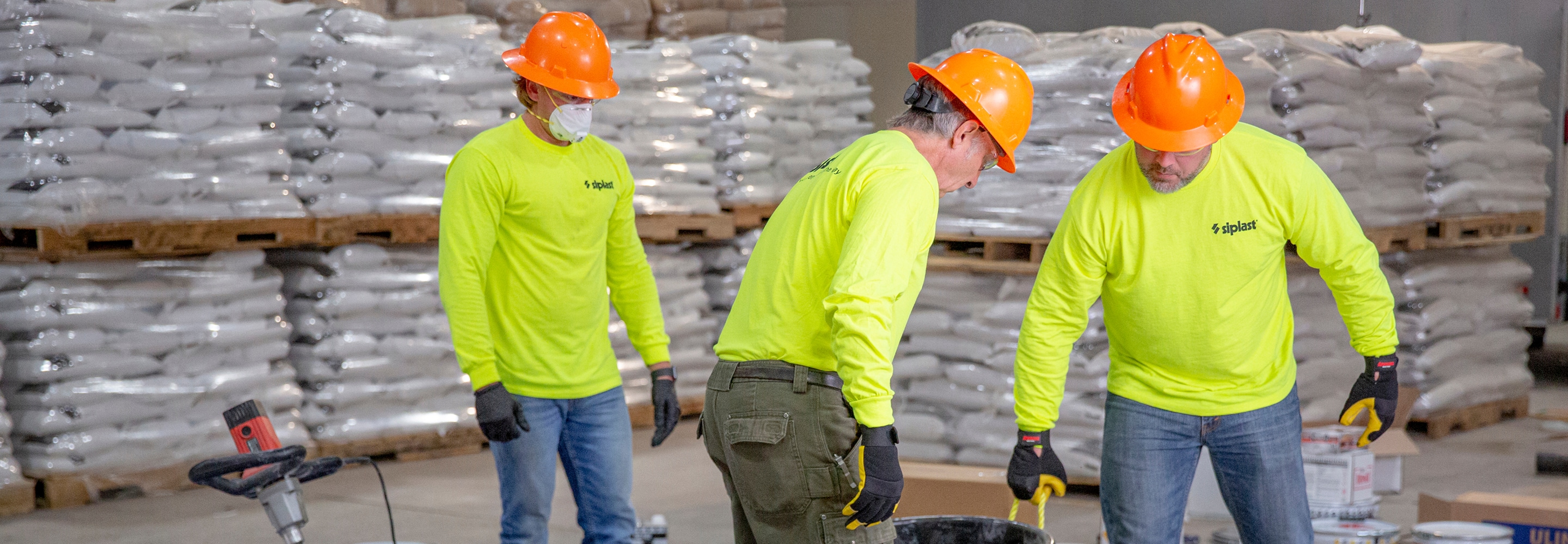 Construction contractors in hardhats and high-vis shirts working in a warehouse, representing available Contractor Resources.