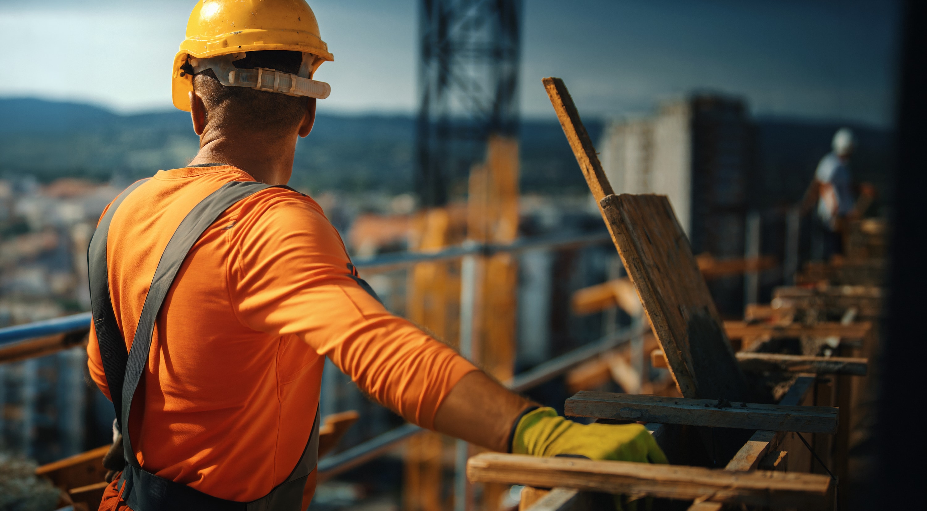 Siplast Select Contractor wearing a yellow hardhat overlooking a commercial construction job site.