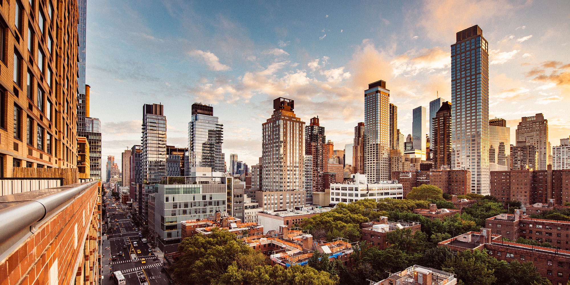 A vibrant New York City skyline at sunset, showcasing numerous commercial buildings and rooftops where Siplast roofing and waterproofing guarantees provide reliable protection for building owners.