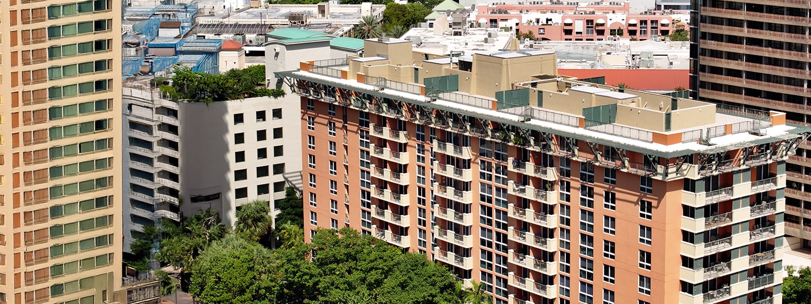 High-angle perspective of the multi-story hotel building featuring a newly installed flat roofing system surrounded by an urban skyline.