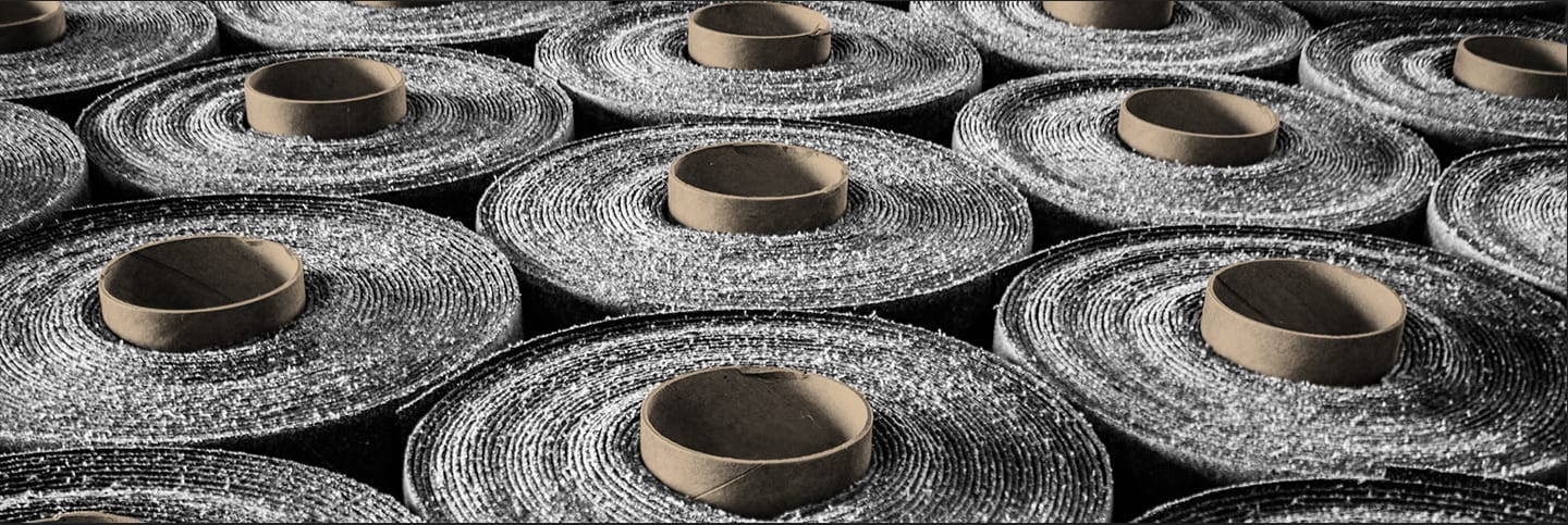 Rolls of Siplast roofing membranes with embedded with RoofTag emphasizing advanced roof asset identification technology.