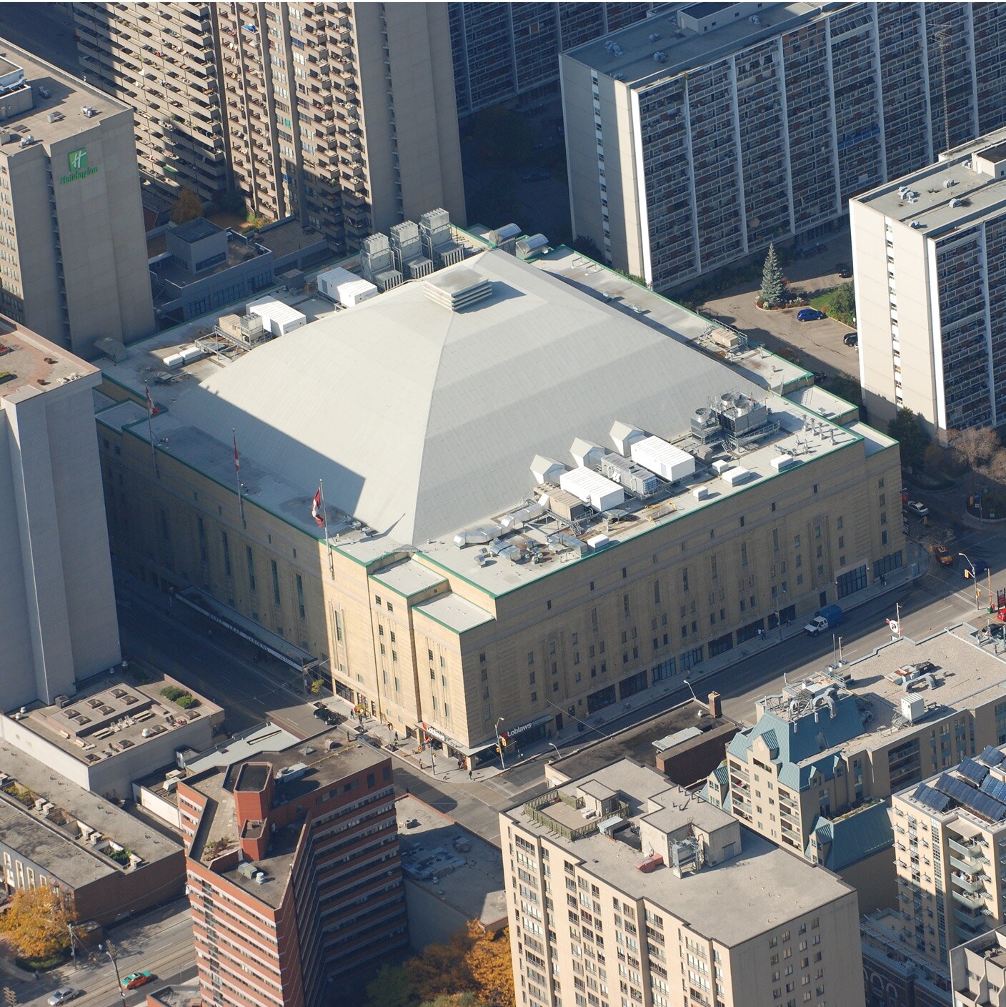 Aerial view of Maple Leafs Garden Arena surrounded by city skyscrapers.