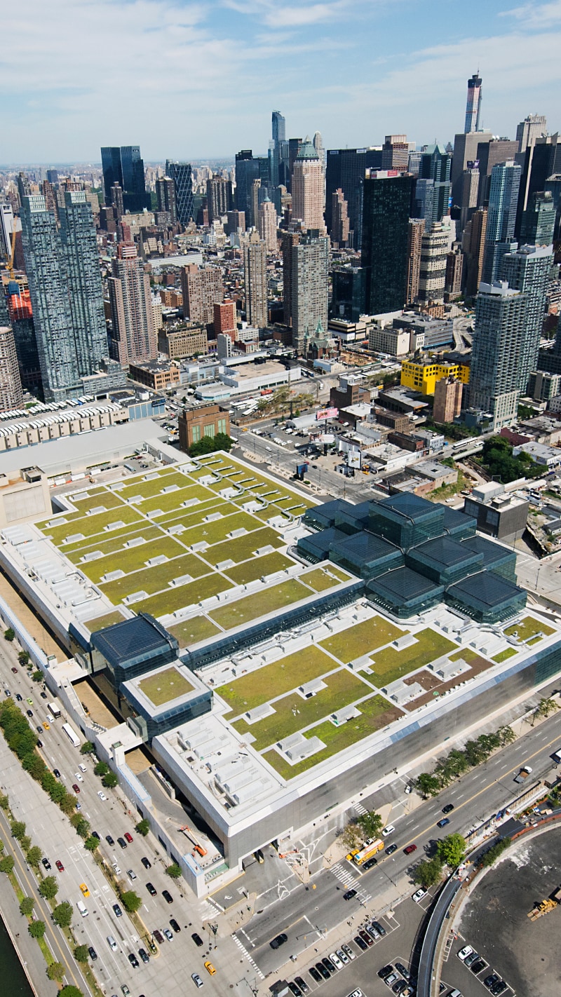 Extensive green roof atop a convention center nestled within a dense cityscape