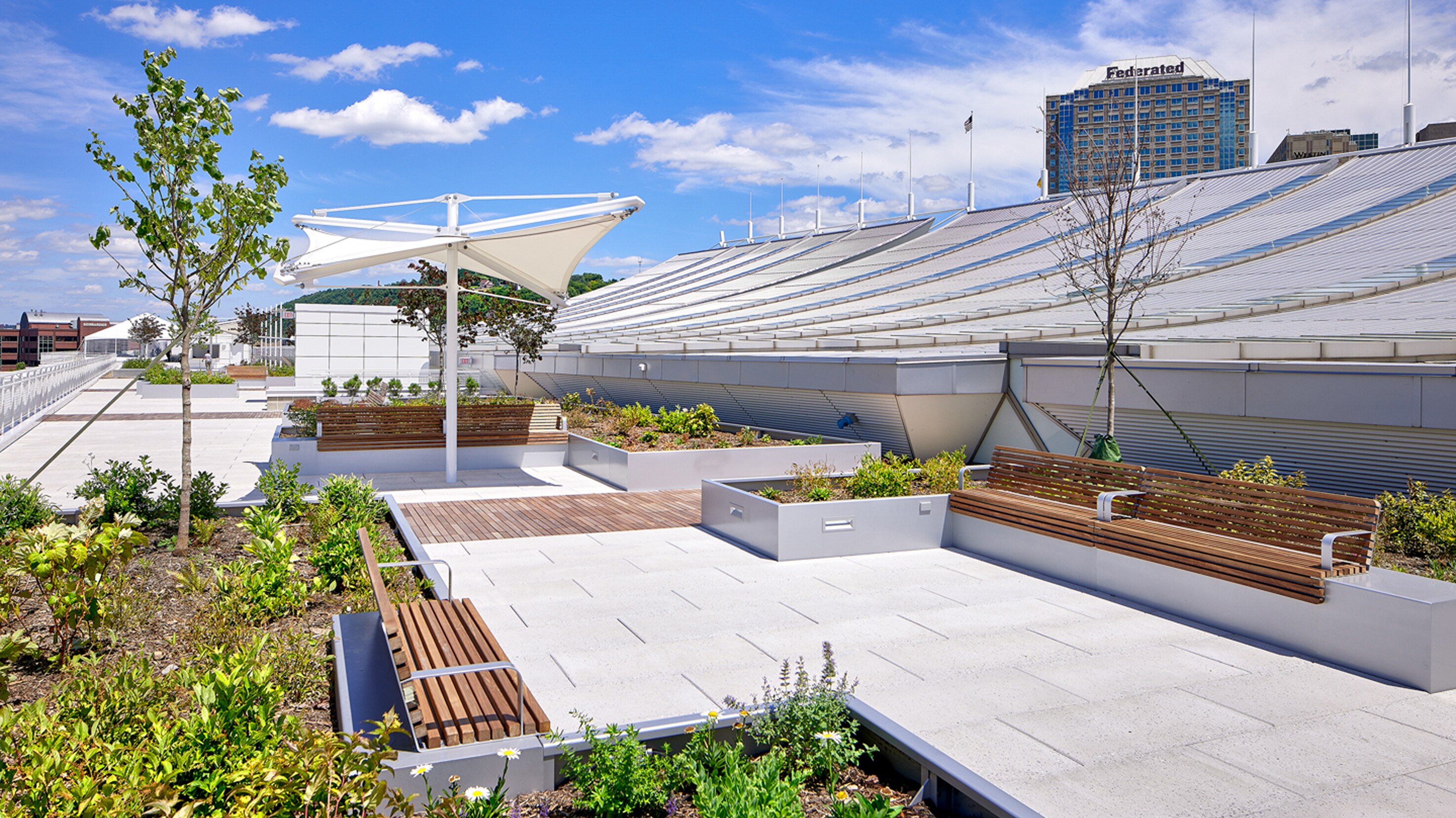 Rooftop amenity system photo featuring pavers, artificial turf, and planters installed over waterproofing.