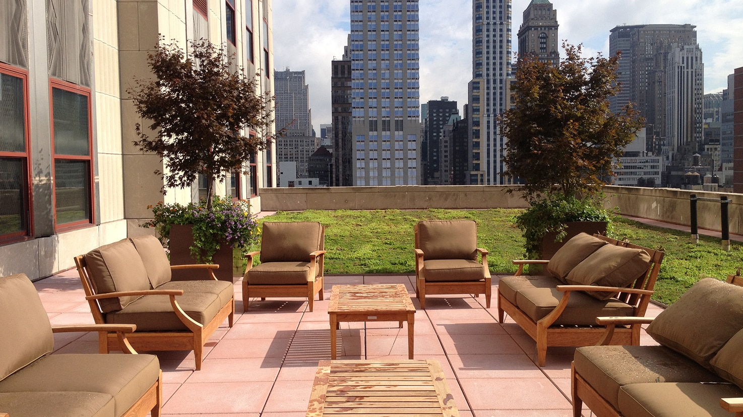 Rooftop terrace with wooden lounge chairs and a cityscape, designed for usable outdoor space