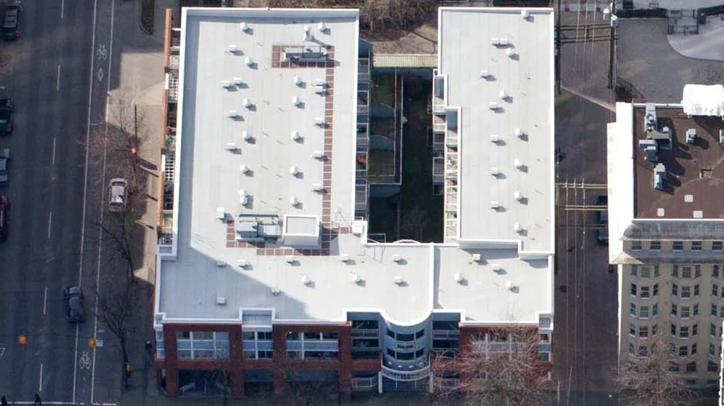 Aerial view of the white roof on Jubilee House apartment building, highlighting a multi-unit reroofing project.