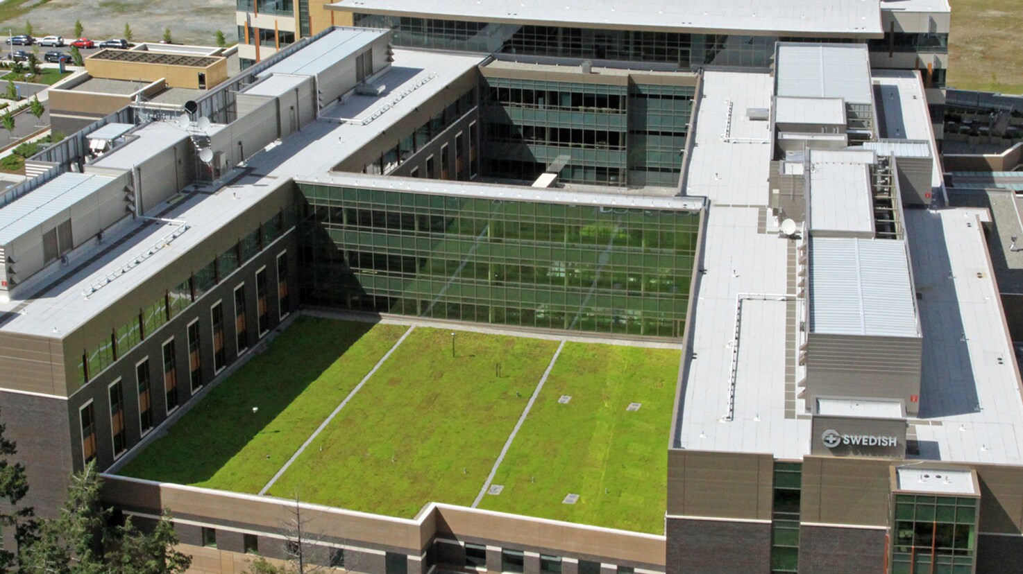 Aerial view of a Swedish Medical Center hospital complex featuring a large, flat green turf courtyard roof.