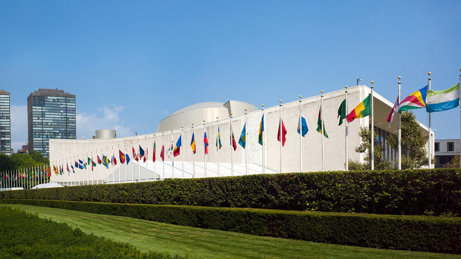 Exterior of the United Nations General Assembly Building with flags, showcasing a Siplast reroofing project profile.